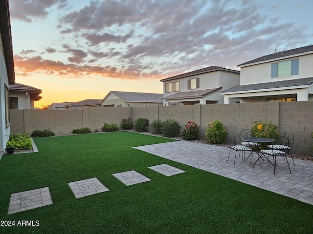 yard at dusk featuring a patio area