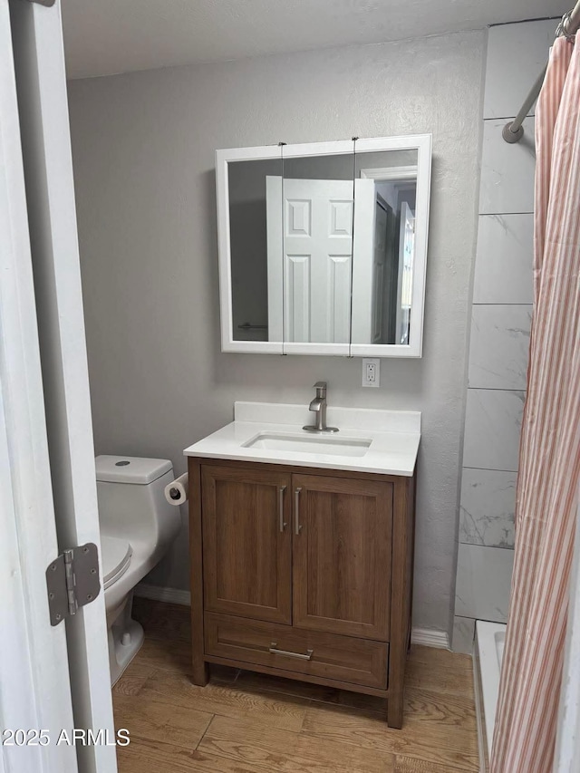 full bath featuring a shower with curtain, vanity, toilet, and wood finished floors