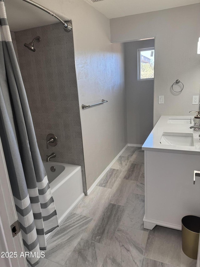 bathroom with double vanity, a sink, shower / tub combo with curtain, and baseboards