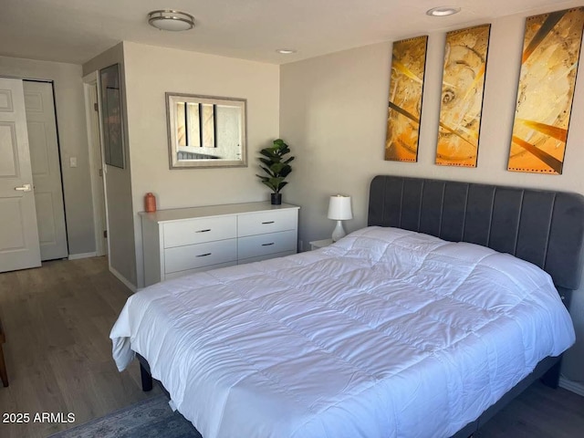 bedroom with wood finished floors, recessed lighting, and baseboards