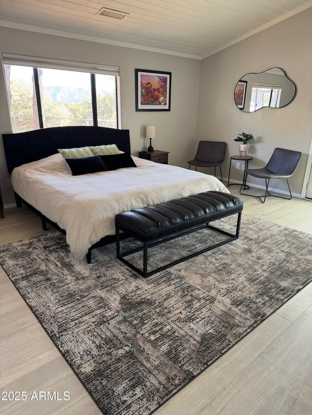bedroom with wooden ceiling, crown molding, visible vents, baseboards, and wood finished floors
