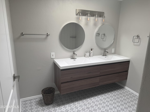 full bath featuring double vanity, tile patterned floors, baseboards, and a sink