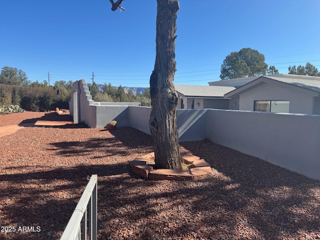 view of side of property featuring stucco siding and fence private yard