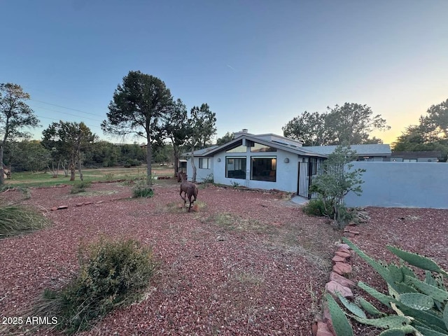 view of front of home with stucco siding and fence