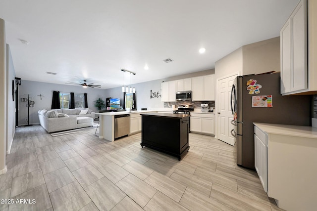 12731 W Myrtle Ave, Glendale, AZ 85307 - kitchen with appliances with stainless steel finishes, open floor plan, a ceiling fan, tasteful backsplash, and a center island