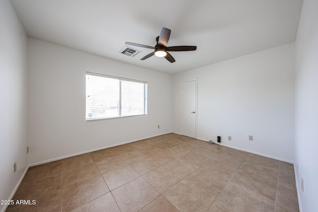 spare room featuring a ceiling fan, light tile patterned floors, and baseboards