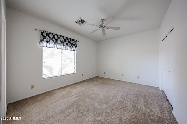 carpeted empty room with ceiling fan and baseboards