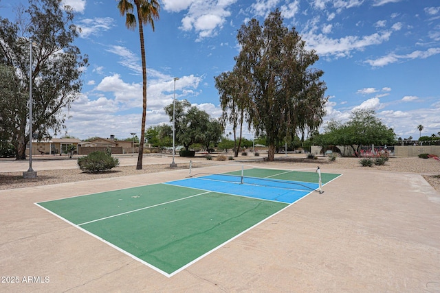 view of sport court with a tennis court and fence