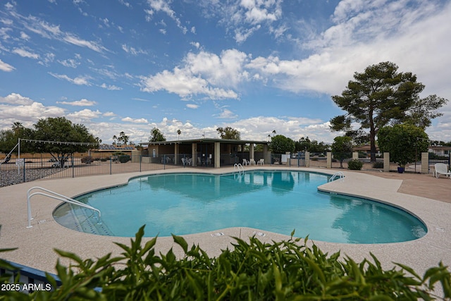 community pool with fence and a patio area