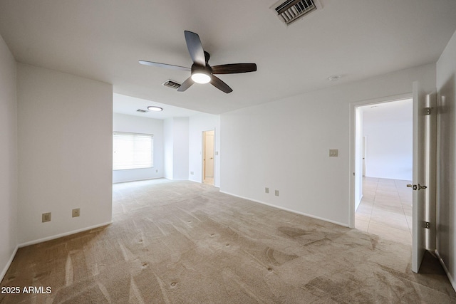 carpeted spare room with ceiling fan and baseboards