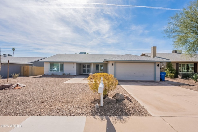 single story home featuring a garage, driveway, and fence