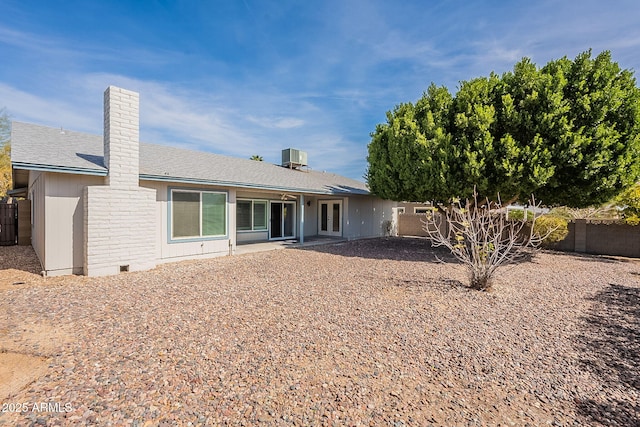 back of house with central AC, a fenced backyard, a patio, and a chimney