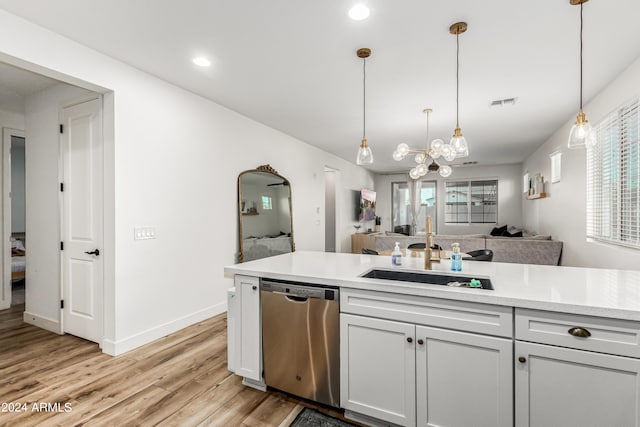 kitchen featuring light wood finished floors, visible vents, dishwasher, light countertops, and a sink