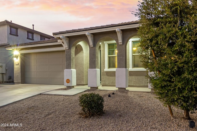 ranch-style home with an attached garage, driveway, and stucco siding