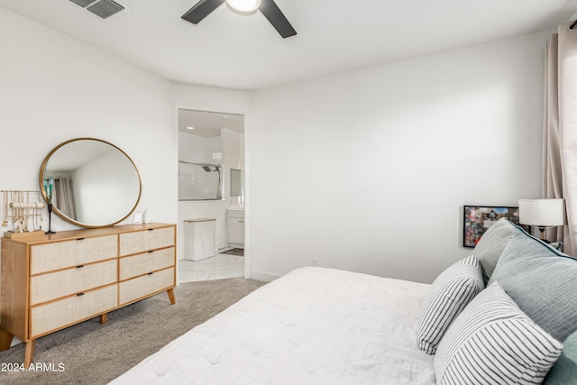 carpeted bedroom featuring ensuite bath and visible vents