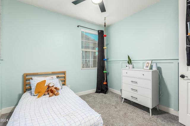 bedroom featuring light colored carpet, baseboards, and ceiling fan