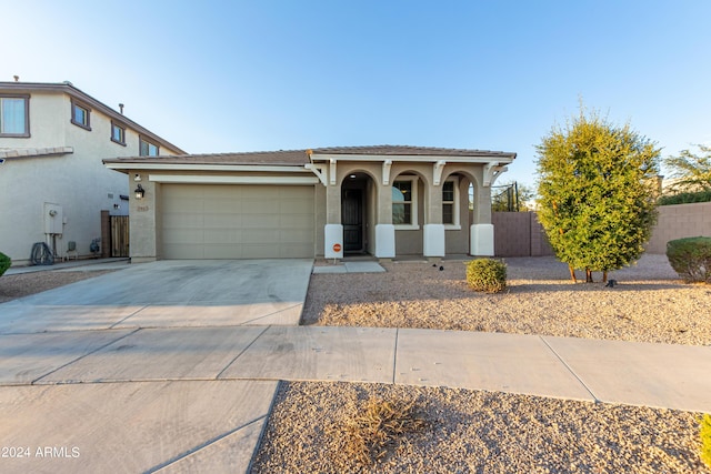 view of front of house featuring an attached garage, fence, driveway, and stucco siding