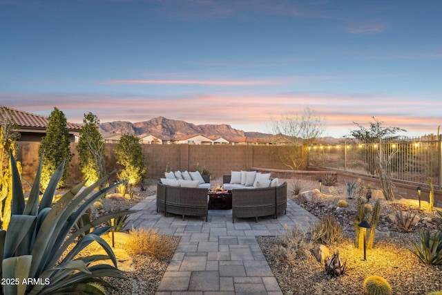 patio terrace at dusk featuring a mountain view and an outdoor hangout area