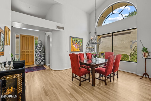 10429 N 101st St, Scottsdale, AZ 85258 - dining space featuring wood finished floors, baseboards, high vaulted ceiling, and arched walkways