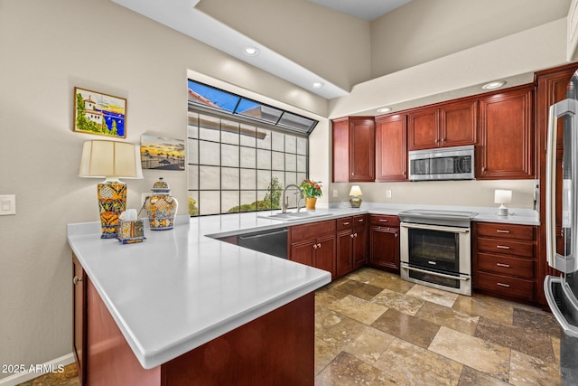 10429 N 101st St, Scottsdale, AZ 85258 - kitchen with stainless steel appliances, a sink, a peninsula, light countertops, and stone finish flooring
