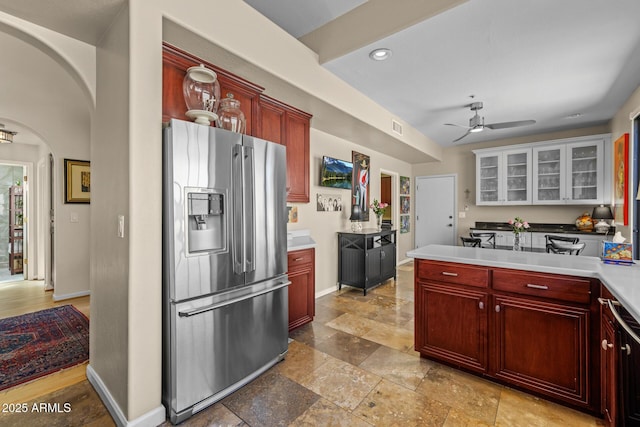 10429 N 101st St, Scottsdale, AZ 85258 - kitchen featuring stainless steel fridge, dark brown cabinets, arched walkways, ceiling fan, and glass insert cabinets