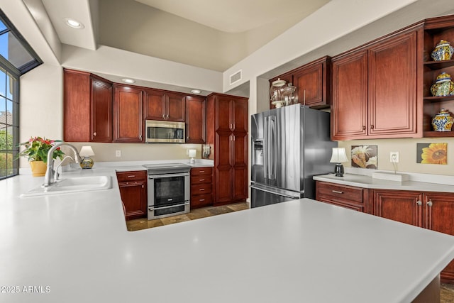 10429 N 101st St, Scottsdale, AZ 85258 - kitchen featuring appliances with stainless steel finishes, a sink, open shelves, reddish brown cabinets, and light countertops