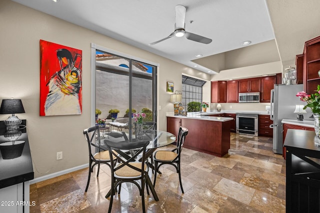 10429 N 101st St, Scottsdale, AZ 85258 - dining area featuring stone tile flooring, a ceiling fan, and baseboards