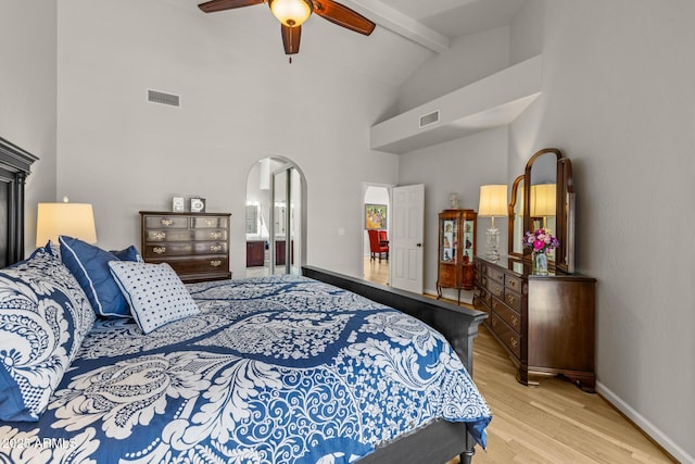 10429 N 101st St, Scottsdale, AZ 85258 - bedroom featuring light wood finished floors, beam ceiling, arched walkways, high vaulted ceiling, and baseboards