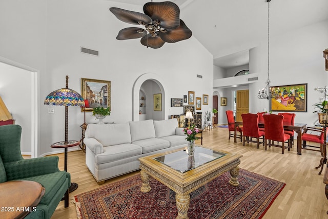 10429 N 101st St, Scottsdale, AZ 85258 - living area featuring high vaulted ceiling, a ceiling fan, a chandelier, arched walkways, and light wood finished floors