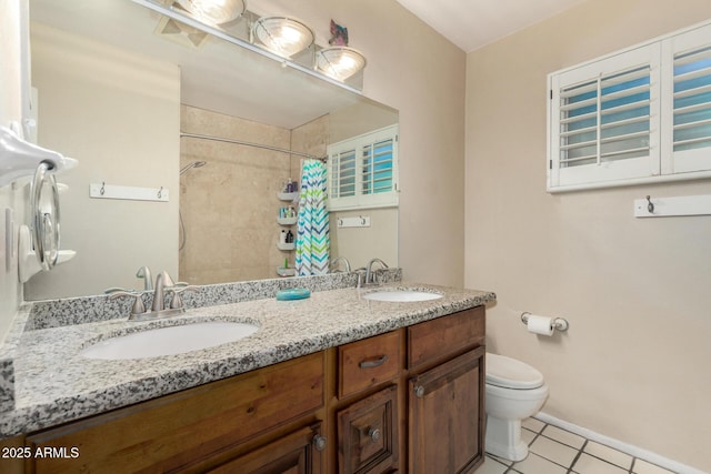 full bath with double vanity, tile patterned flooring, toilet, and a sink