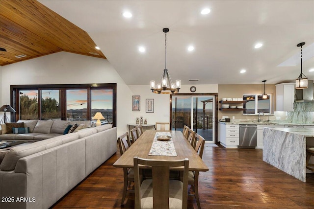 dining space with lofted ceiling, sink, a chandelier, and dark hardwood / wood-style flooring