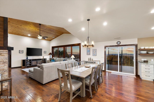 dining space with lofted ceiling, dark hardwood / wood-style floors, and ceiling fan with notable chandelier