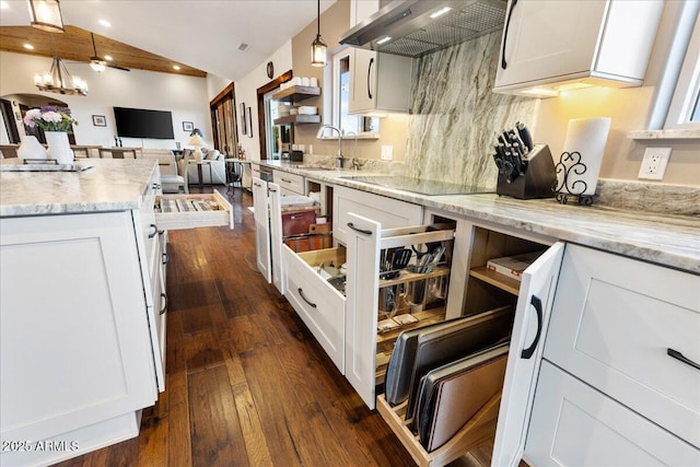 kitchen with pendant lighting, white cabinets, black electric cooktop, and wall chimney exhaust hood