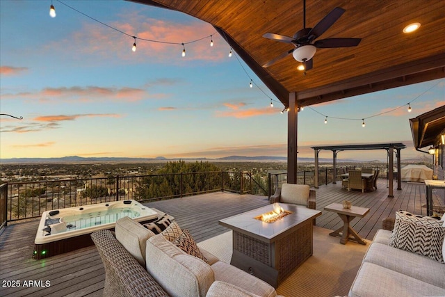 deck at dusk featuring an outdoor living space with a fire pit