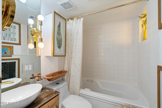 full bathroom featuring shower / bath combo, toilet, tile walls, and vanity