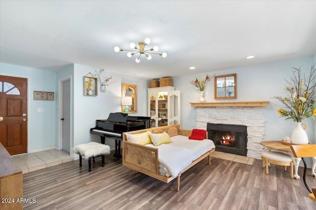 living room with a fireplace, hardwood / wood-style floors, and an inviting chandelier