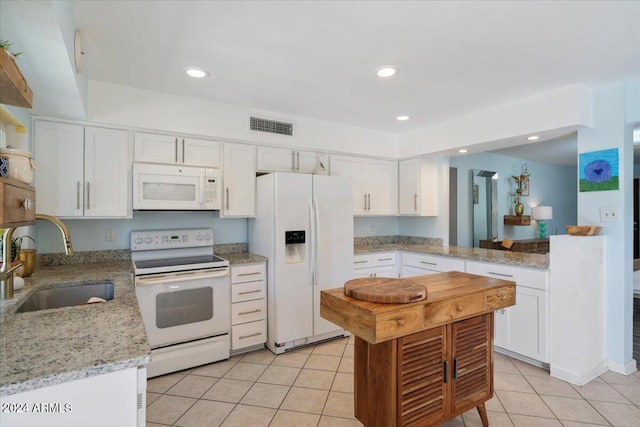 kitchen featuring white appliances, sink, light stone countertops, light tile patterned floors, and white cabinetry