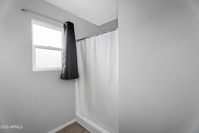 full bath with baseboards, a shower with curtain, and wood finished floors