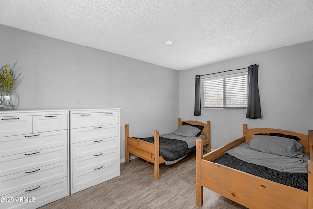 bedroom with light wood finished floors and a textured ceiling