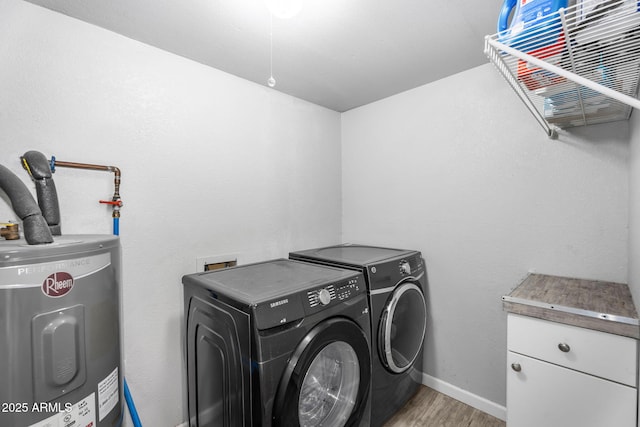 laundry room with light wood-style floors, water heater, cabinet space, baseboards, and independent washer and dryer