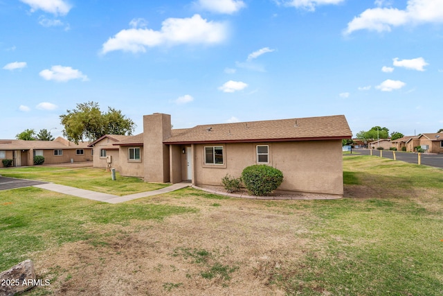 ranch-style home with a front yard, stucco siding, and fence