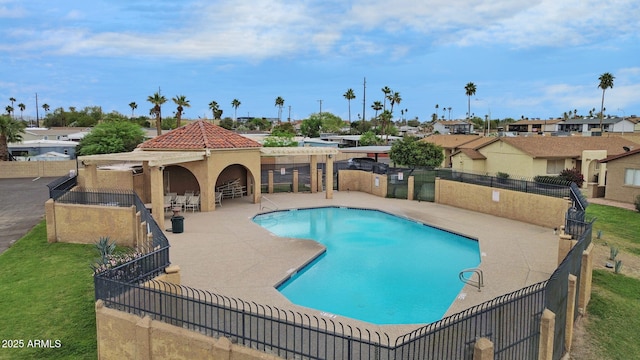 community pool with fence, a residential view, and a patio