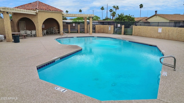 community pool featuring fence and a patio