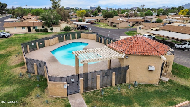 community pool with fence, a gate, a residential view, and a wall unit AC