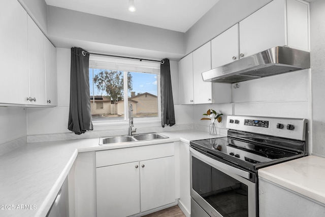 kitchen with white cabinets, a sink, stainless steel range with electric cooktop, light countertops, and under cabinet range hood