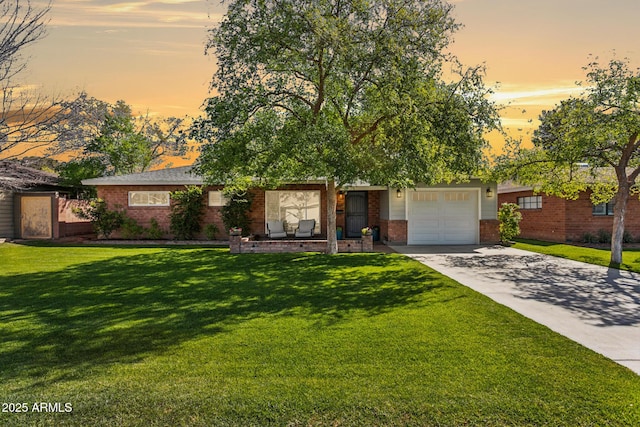 view of front of house featuring brick siding, an attached garage, concrete driveway, and a front yard