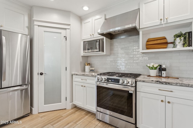 kitchen featuring white cabinets, wall chimney exhaust hood, light wood-style floors, and stainless steel appliances