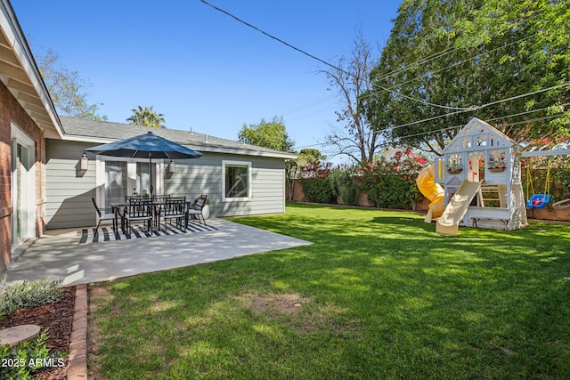 view of yard featuring a patio area, a playground, and a fenced backyard