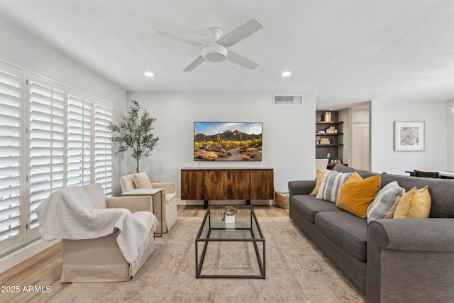 living room with visible vents, recessed lighting, a ceiling fan, and light wood-style floors