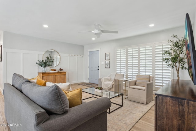 living area featuring recessed lighting, light wood-style flooring, a decorative wall, and ceiling fan